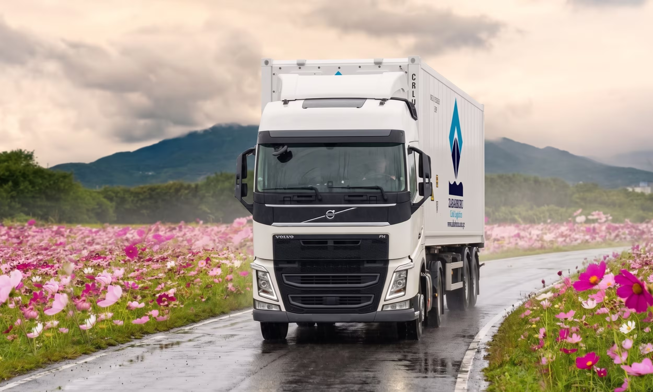 Camión blanco transportando un contenedor refrigerado de 40 pies a través de una carretera en medio de flores